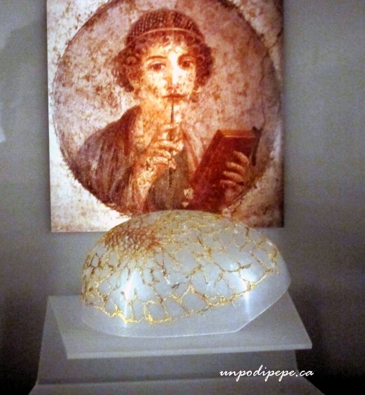 Reticula (hairnet) of finely woven gold, found on Via Tiburtina, Palazzo Massimo. In behind is the poet Sappho wearing a hairnet, from a Pompeiian fresco.